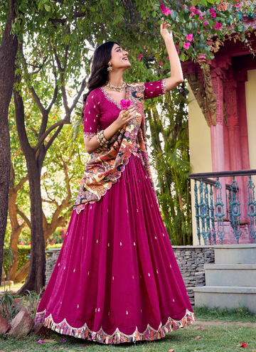 Mesmerizing Rani color Vichitra SIlk lehenga choli with sequin embroidery and kalamkari border.